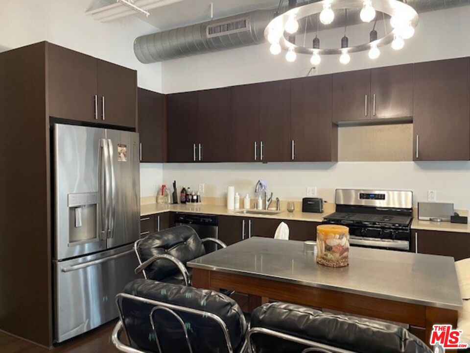 1645 Vine Street, Unit 703 Los Angeles, CA 90028 - Photo 41 of 44 a kitchen with stainless steel appliances granite countertop a refrigerator a stove a sink dishwasher and refrigerator with wooden floor