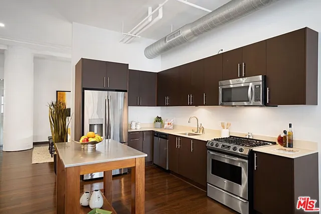 a kitchen with stainless steel appliances a stove microwave and refrigerator