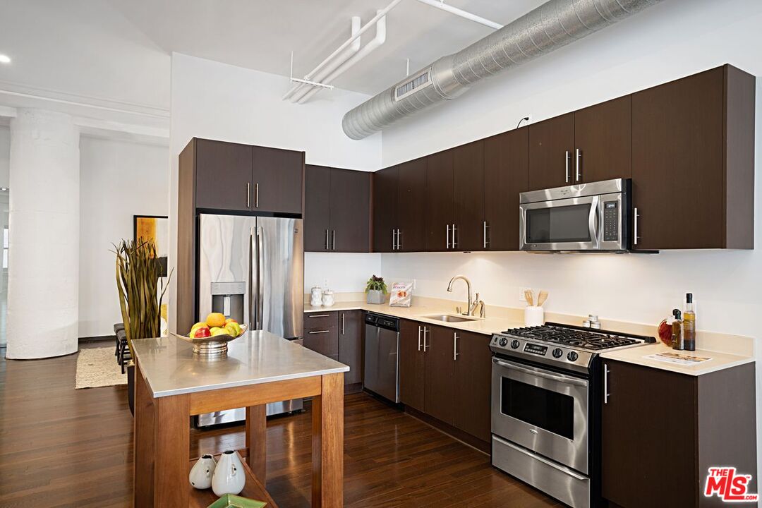 1645 Vine Street, Unit 703 Los Angeles, CA 90028 - Photo 9 of 44 a kitchen with stainless steel appliances a stove microwave and refrigerator