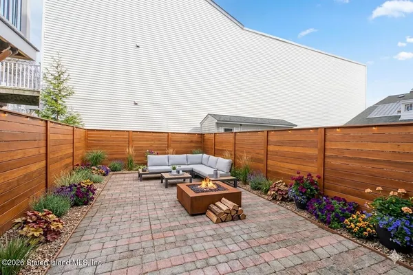 a roof deck with table and chairs potted plants