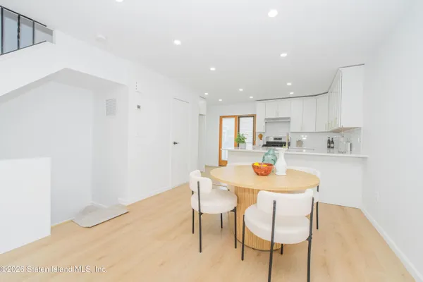 a kitchen with a dining table chairs and white cabinets