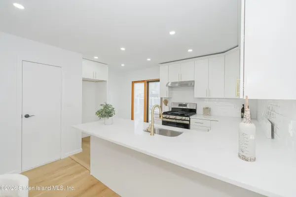 a kitchen with stainless steel appliances a sink a stove a refrigerator and cabinets