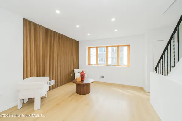 a view of a livingroom with wooden furniture and windows