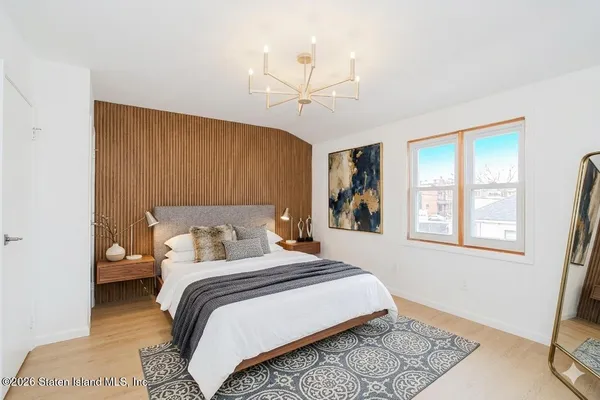 a bedroom with a bed lamp and a chandelier
