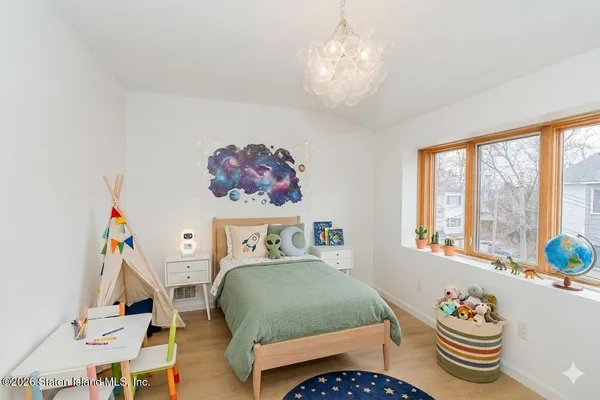 a bedroom with furniture and a large window