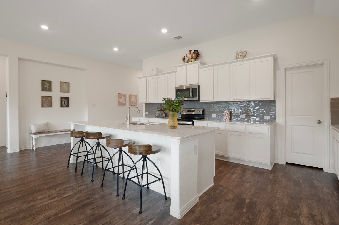 1437 Morning View Road Georgetown, TX 78628 - Photo 6 of 24 a kitchen with stainless steel appliances a white table chairs and a refrigerator