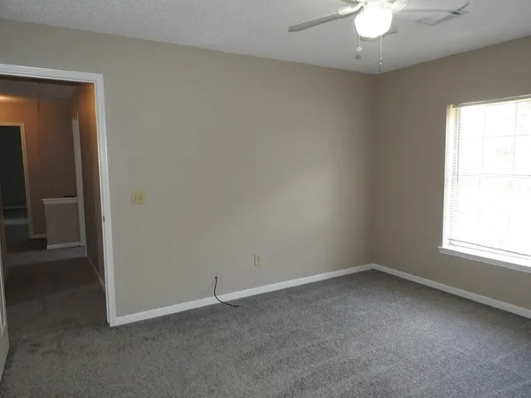 an empty room with a chandelier fan