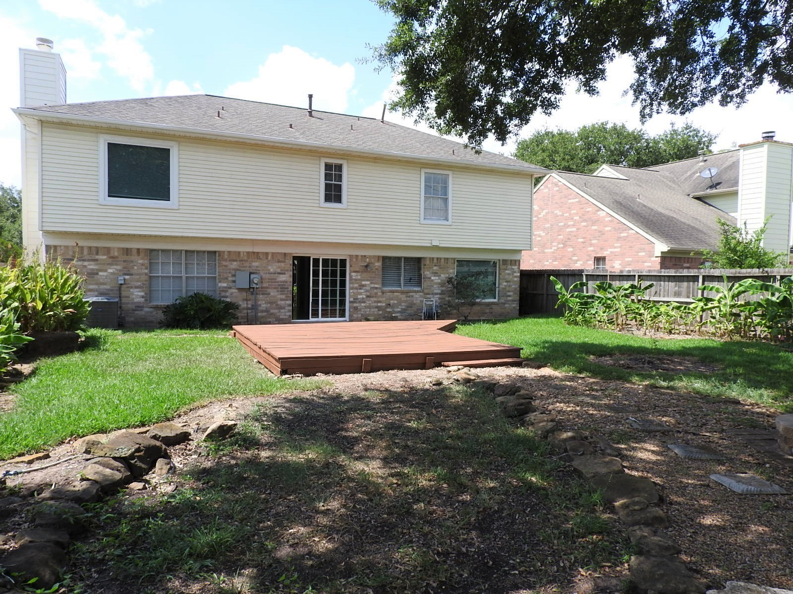 3107 Rimrock Drive Missouri City, TX 77459 - Photo 31 of 32 a view of a white house with a yard plants and large tree