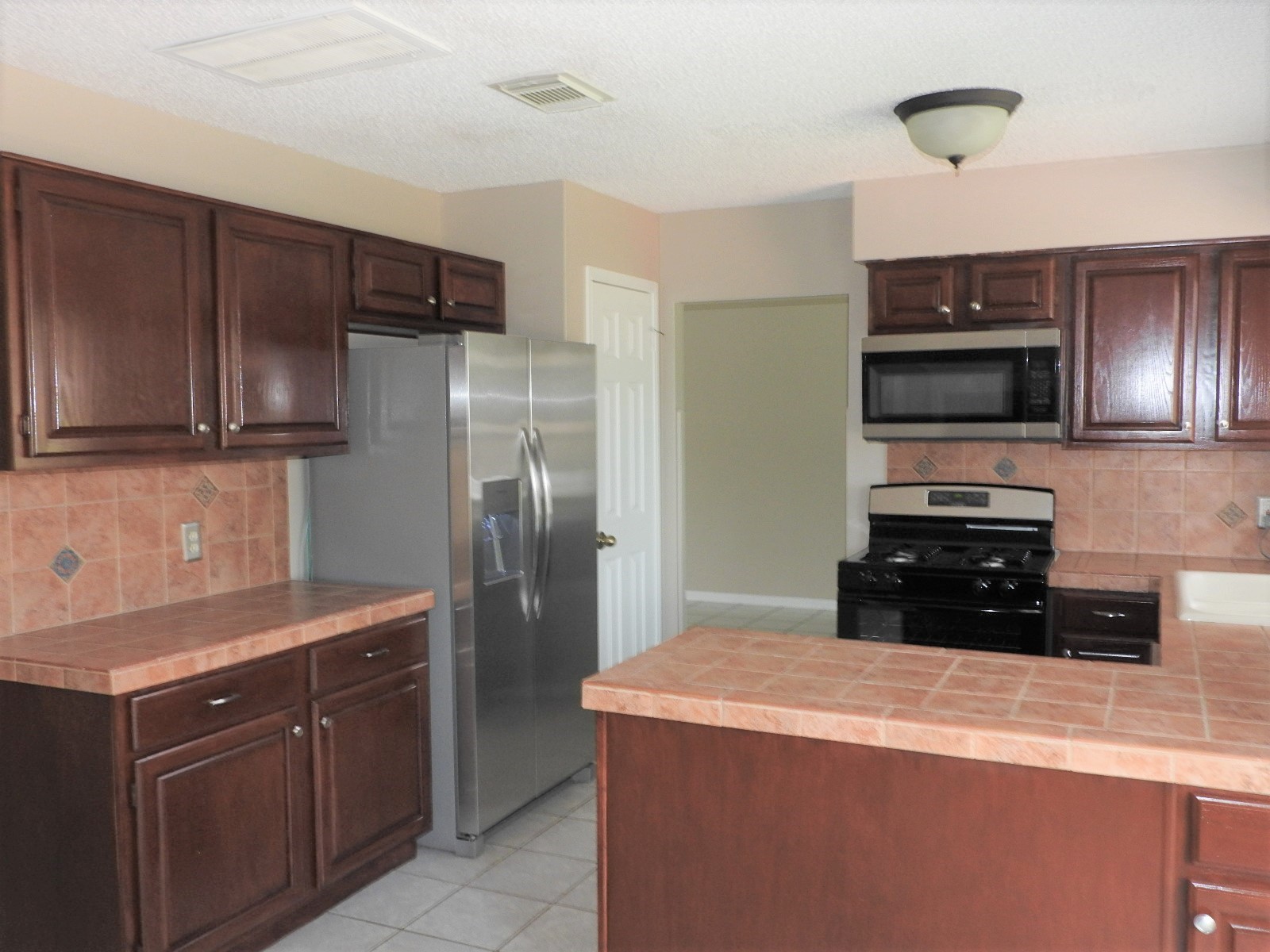 3107 Rimrock Drive Missouri City, TX 77459 - Photo 5 of 32 a kitchen with a refrigerator and a sink