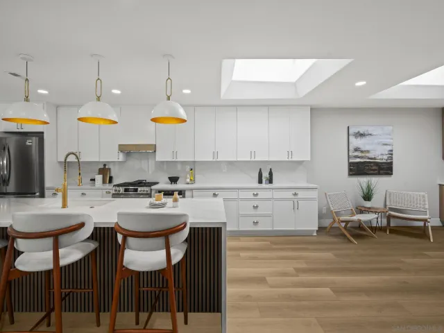 a kitchen with cabinets a sink and chairs