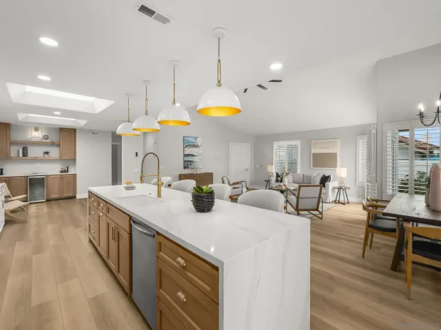 a kitchen with stainless steel appliances kitchen island granite countertop a table chairs sink and cabinets