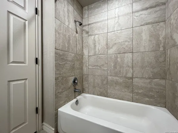 a white bath tub sitting next to a white sink and vanity