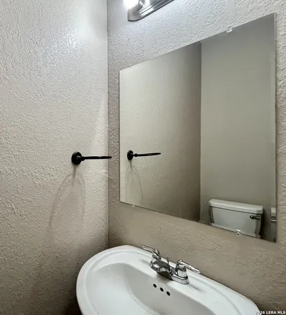 a bathroom with a sink a toilet and mirror