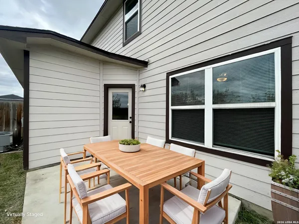 a backyard of a house with table and chairs