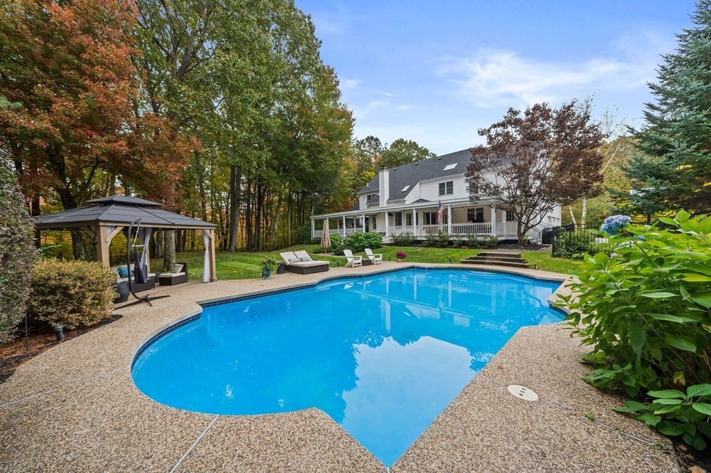 105 Waterman Road Canton, MA 02021 - Photo 37 of 39 a view of a swimming pool with lawn chairs under an umbrella
