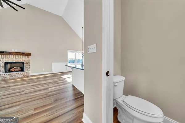 a bathroom with a toilet and a hardwood floor