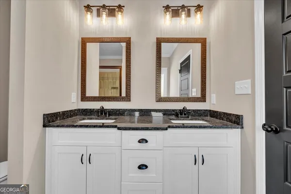 a bathroom with a granite countertop sink and a mirror