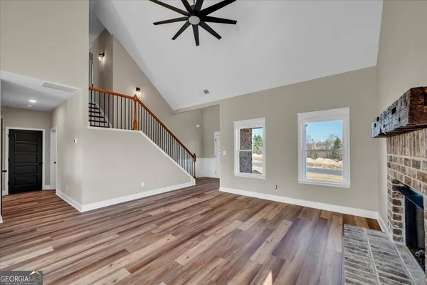 a view of an empty room and window with wooden floor