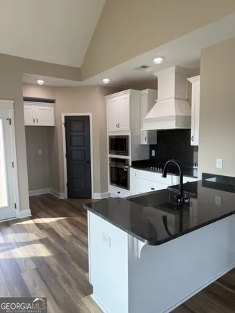 a kitchen with stainless steel appliances granite countertop a sink and a refrigerator