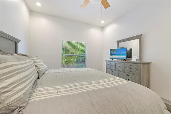a spacious bedroom with a bed and a dresser