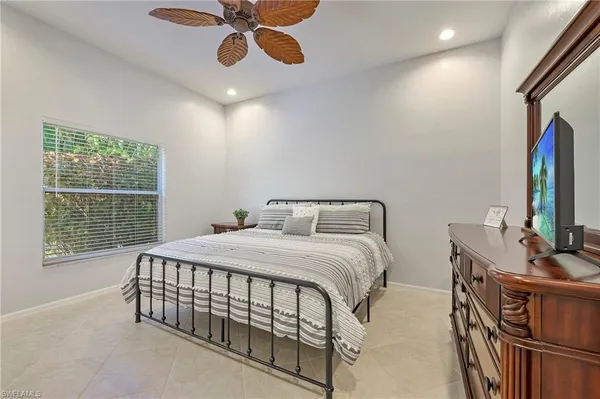 a bedroom with a bed a chandelier and dresser