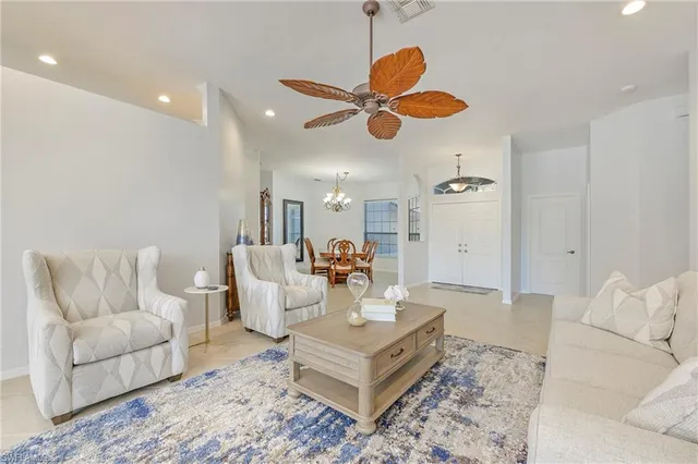 a living room with furniture kitchen view and a chandelier