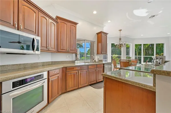 a kitchen with stainless steel appliances granite countertop a stove a sink and a microwave