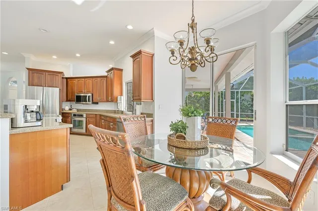 a view of a dining room with furniture a kitchen and chandelier