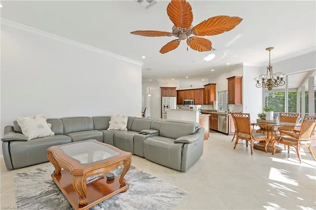 a living room with furniture kitchen view and a chandelier