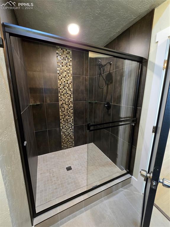 33036 Meadow Ridge Lane Trinidad, CO 81082 - Photo 37 of 50 Bathroom with a shower with door, tile patterned floors, and a textured ceiling