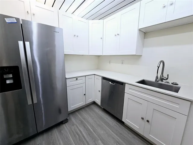 a kitchen with a refrigerator sink and cabinets