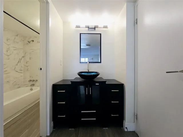 a bathroom with a sink a bathtub and a mirror