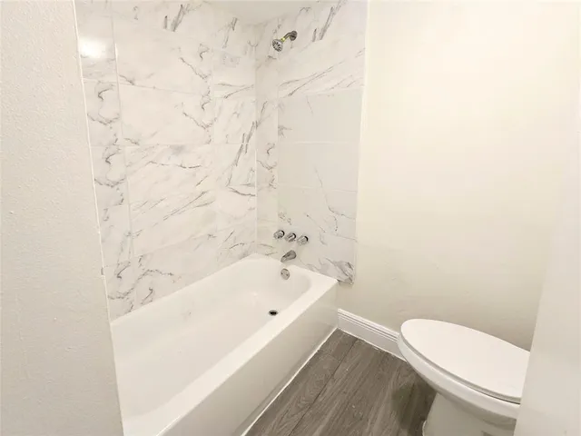 a bathroom with a white toilet and a bathtub