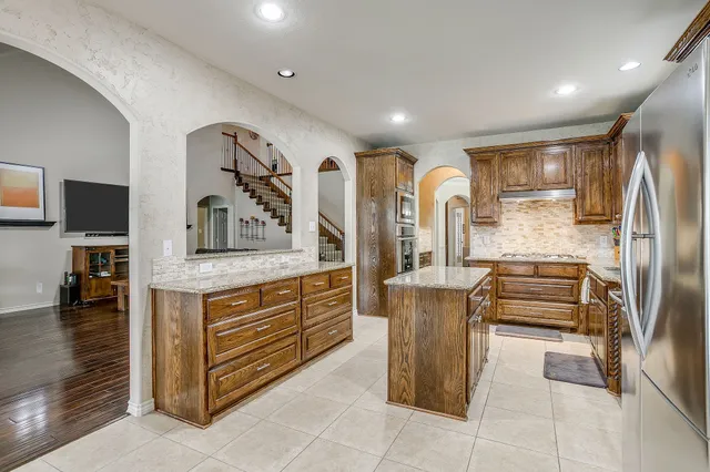 a kitchen with stainless steel appliances granite countertop a sink and a refrigerator