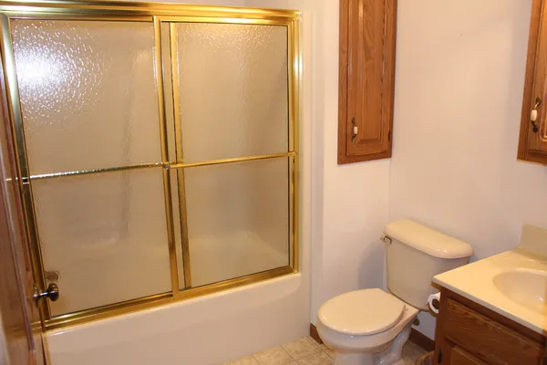 a white toilet sitting next to a shower