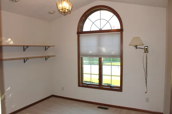an empty room with windows dryer and chandelier