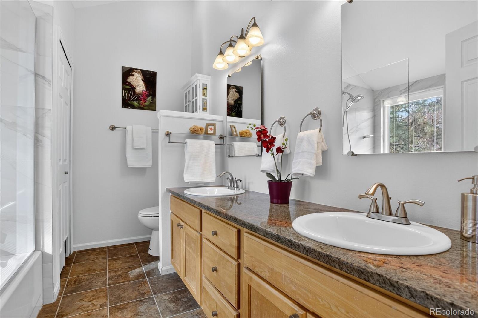 23660 Pondview Place, Unit E Golden, CO 80401 - Photo 14 of 26 a bathroom with a double vanity sink mirror and a toilet