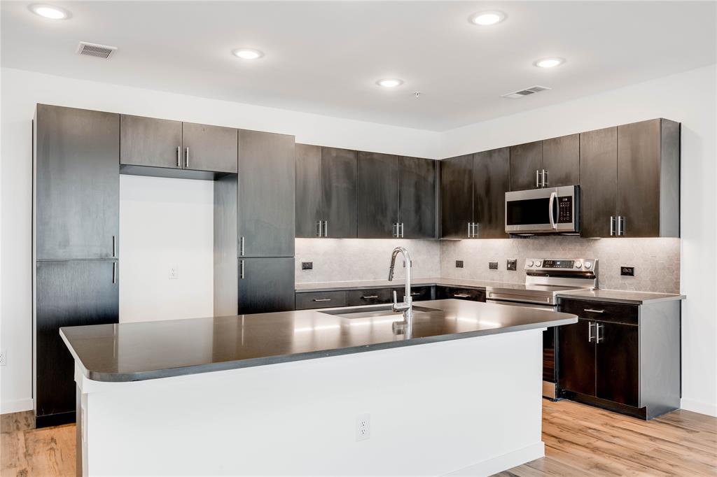 4801 Springdale Road, Unit 1307 Austin, TX 78723 - Photo 3 of 30 a kitchen with stainless steel appliances granite countertop a sink a stove and a refrigerator