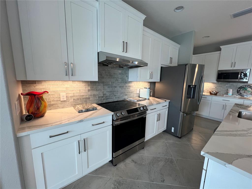 15419 Appleton Boulevard Port Charlotte, FL 33981 - Photo 22 of 43 a kitchen with stainless steel appliances granite countertop a sink stove and refrigerator