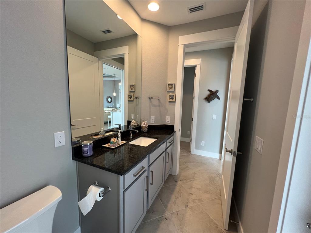 15419 Appleton Boulevard Port Charlotte, FL 33981 - Photo 25 of 43 a bathroom with a granite countertop sink and a mirror