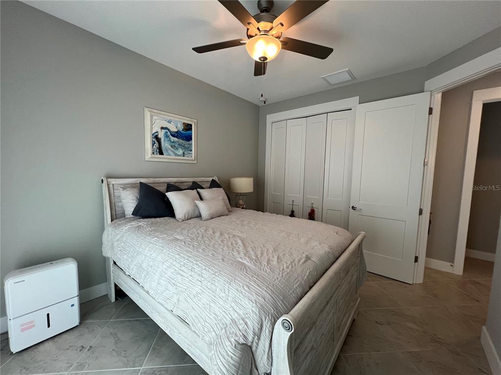15419 Appleton Boulevard Port Charlotte, FL 33981 - Photo 27 of 43 a bedroom with a bed and a chandelier