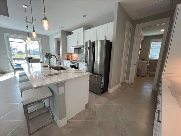a kitchen with kitchen island granite countertop a sink appliances and cabinets