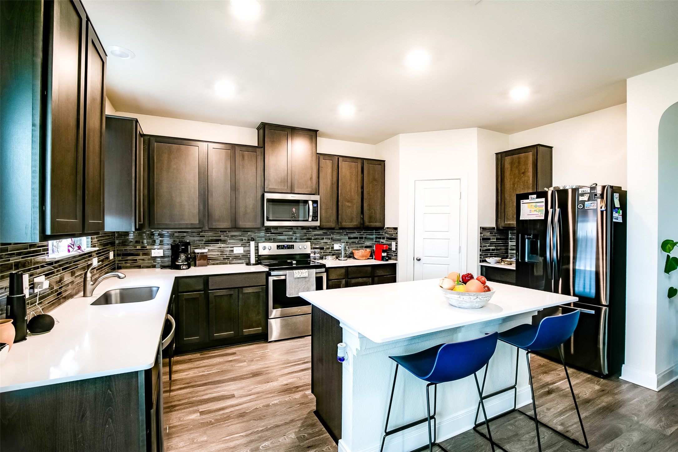 7616 Groundhog Way Austin, TX 78744 - Photo 13 of 34 a kitchen with refrigerator a sink and chairs