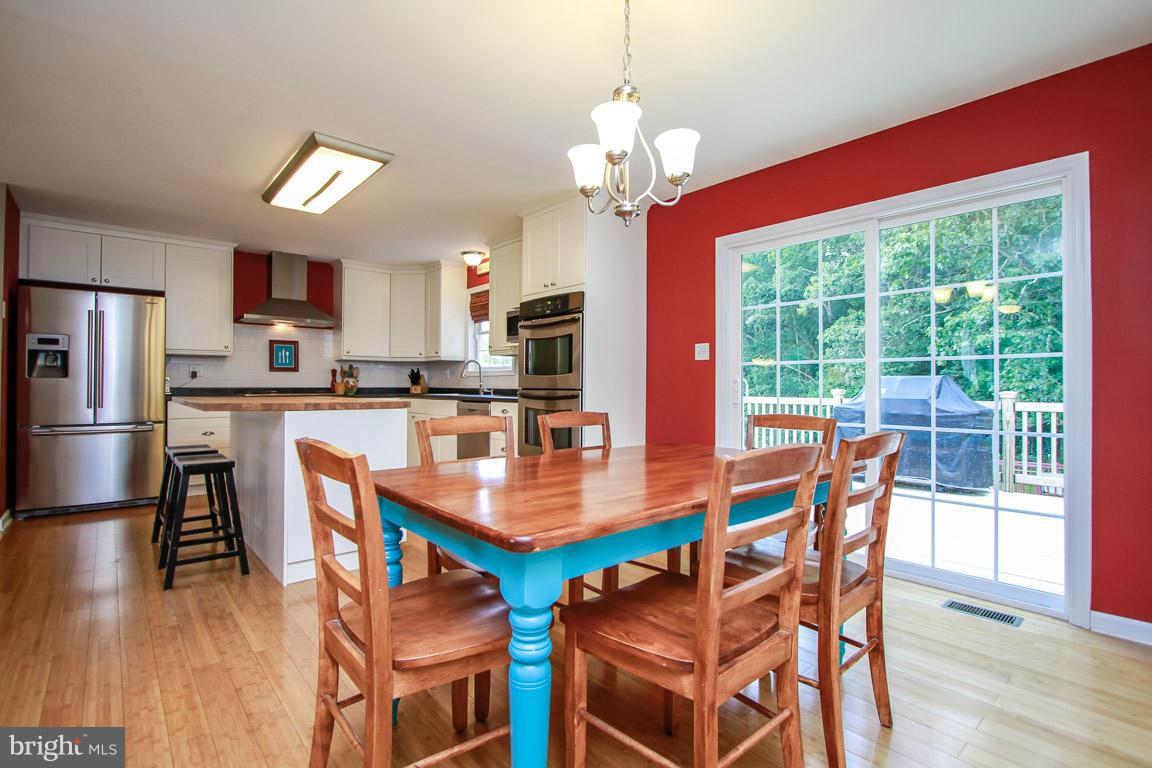 3237 Lineboro Road Manchester, MD 21102 - Photo 11 of 26 a dining room with stainless steel appliances granite countertop a dining table chairs and a refrigerator