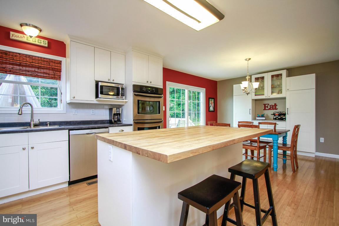 3237 Lineboro Road Manchester, MD 21102 - Photo 13 of 26 a kitchen with stainless steel appliances granite countertop table chairs sink and cabinets