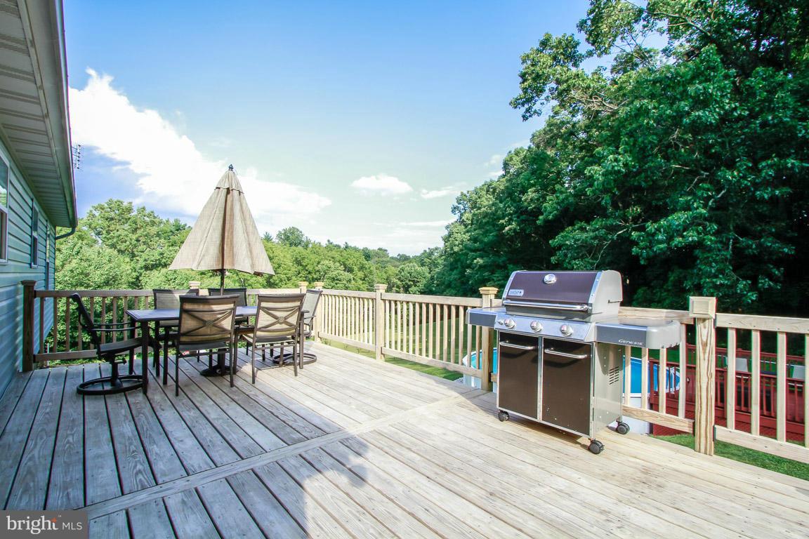 3237 Lineboro Road Manchester, MD 21102 - Photo 3 of 26 a view of a deck with table and chairs a barbeque with wooden floor and fence