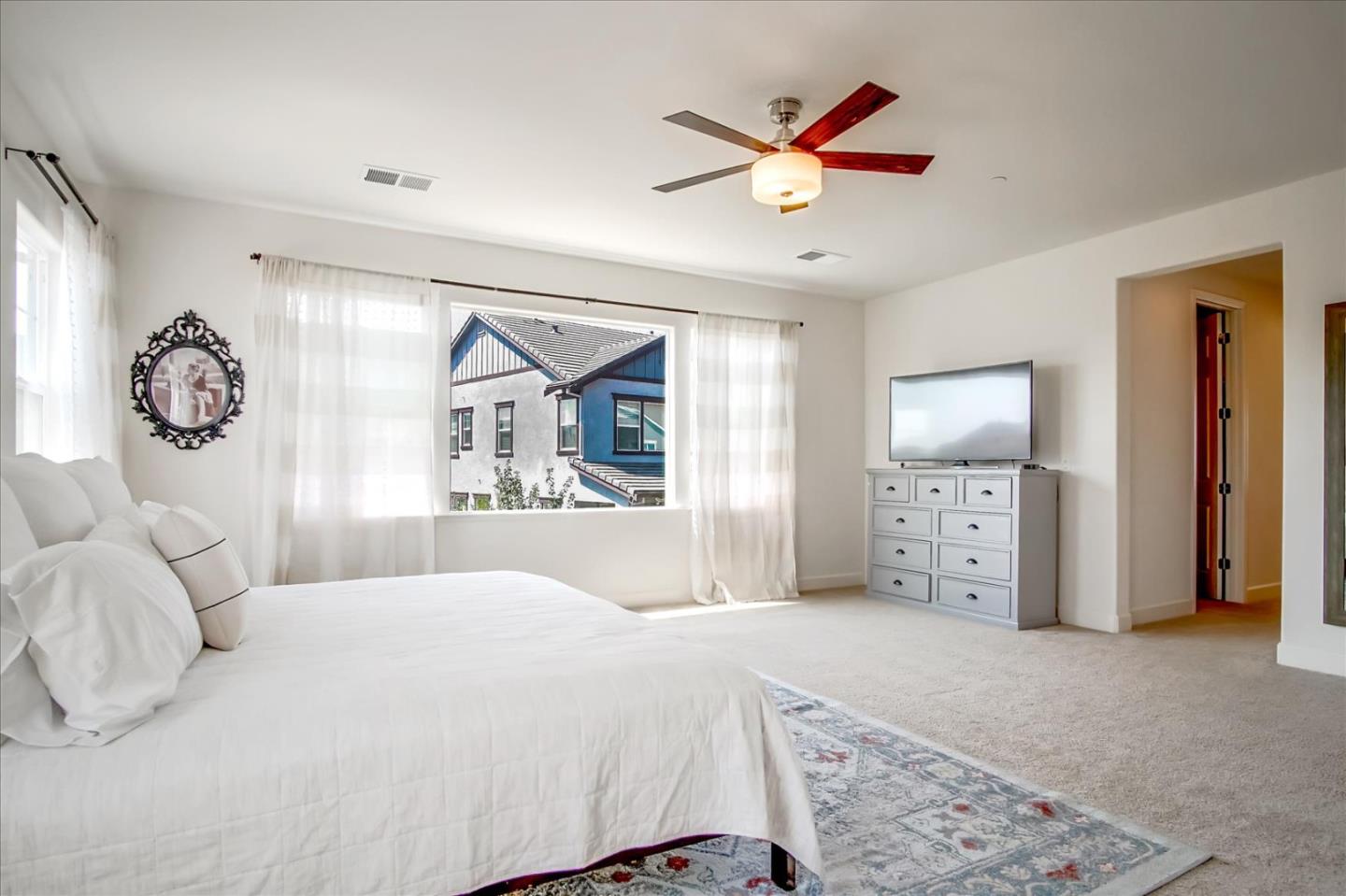1130 Ruby Way Gilroy, CA 95020 - Photo 19 of 36 a bedroom with a large bed and a chandelier