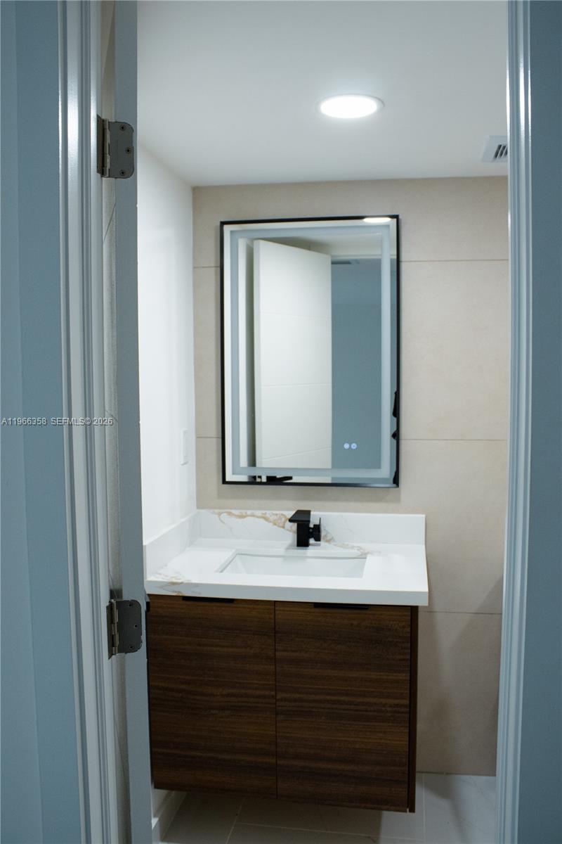 10433 Southwest 118th Court Miami, FL 33186 - Photo 30 of 32 a bathroom with a sink and a mirror
