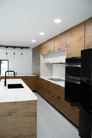 a kitchen with kitchen island a sink and stove