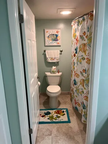 a bathroom with a toilet and a shower curtain